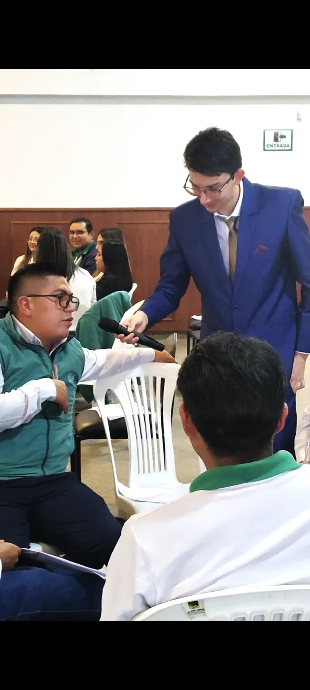 Francesco Arias entregando el micrófono a un participante durante una capacitación